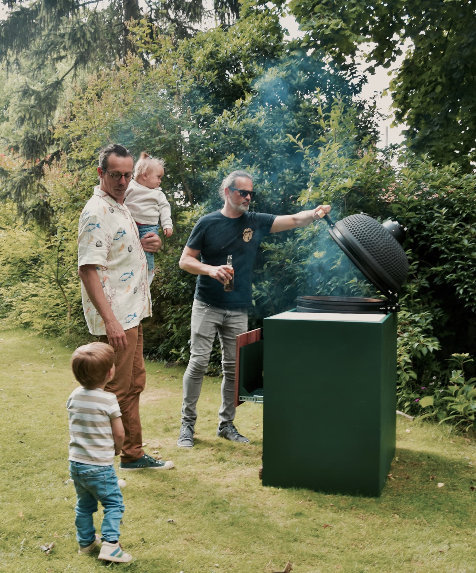 Compact en verplaatsbaar BBQ-onderstel met Big Green Egg in gebruik in de tuin in Gistel