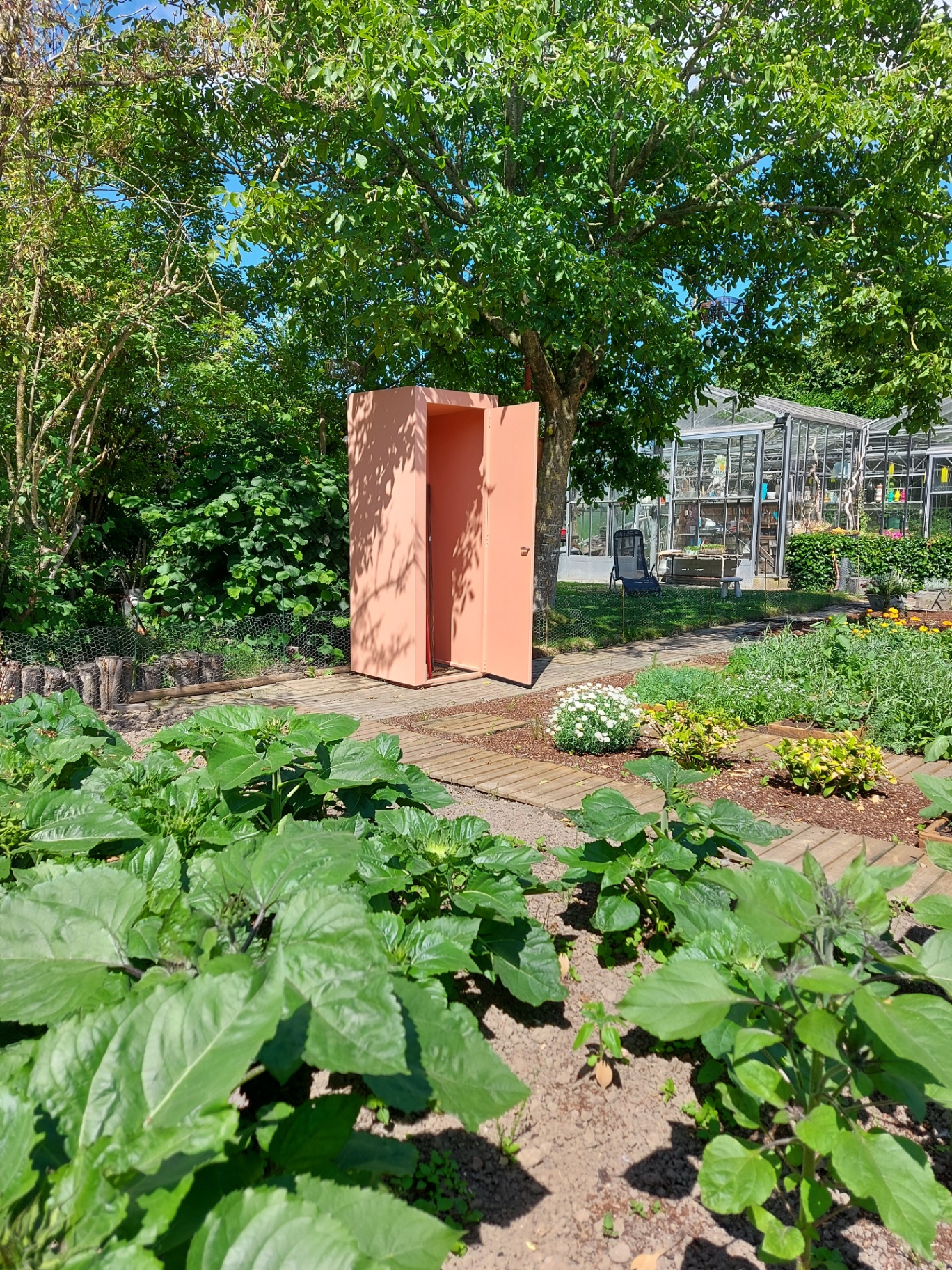 Ansaro gereedschapskast in perzikroze poederlak tussen de moestuinbedden